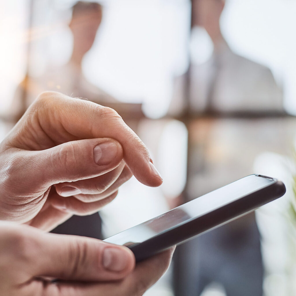 Man uses sms messaging on his phone to increase customer engagement for his business.